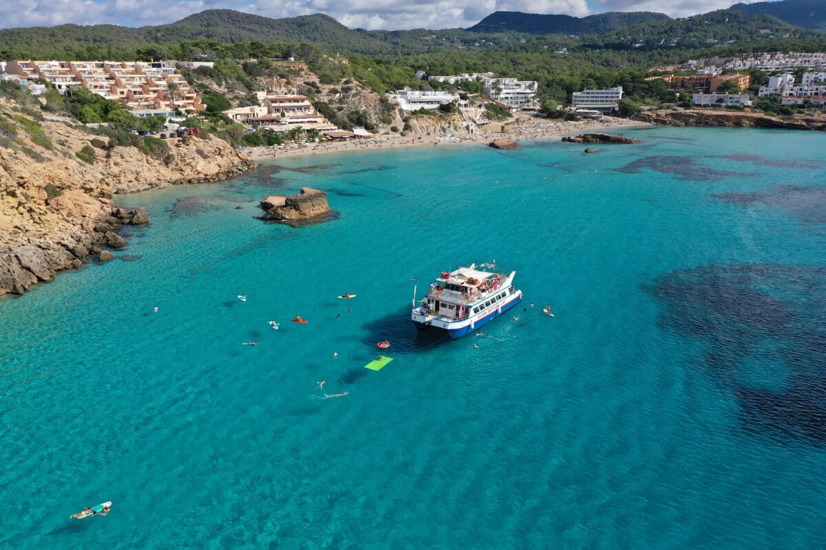 A boat is floating in the water near a beach