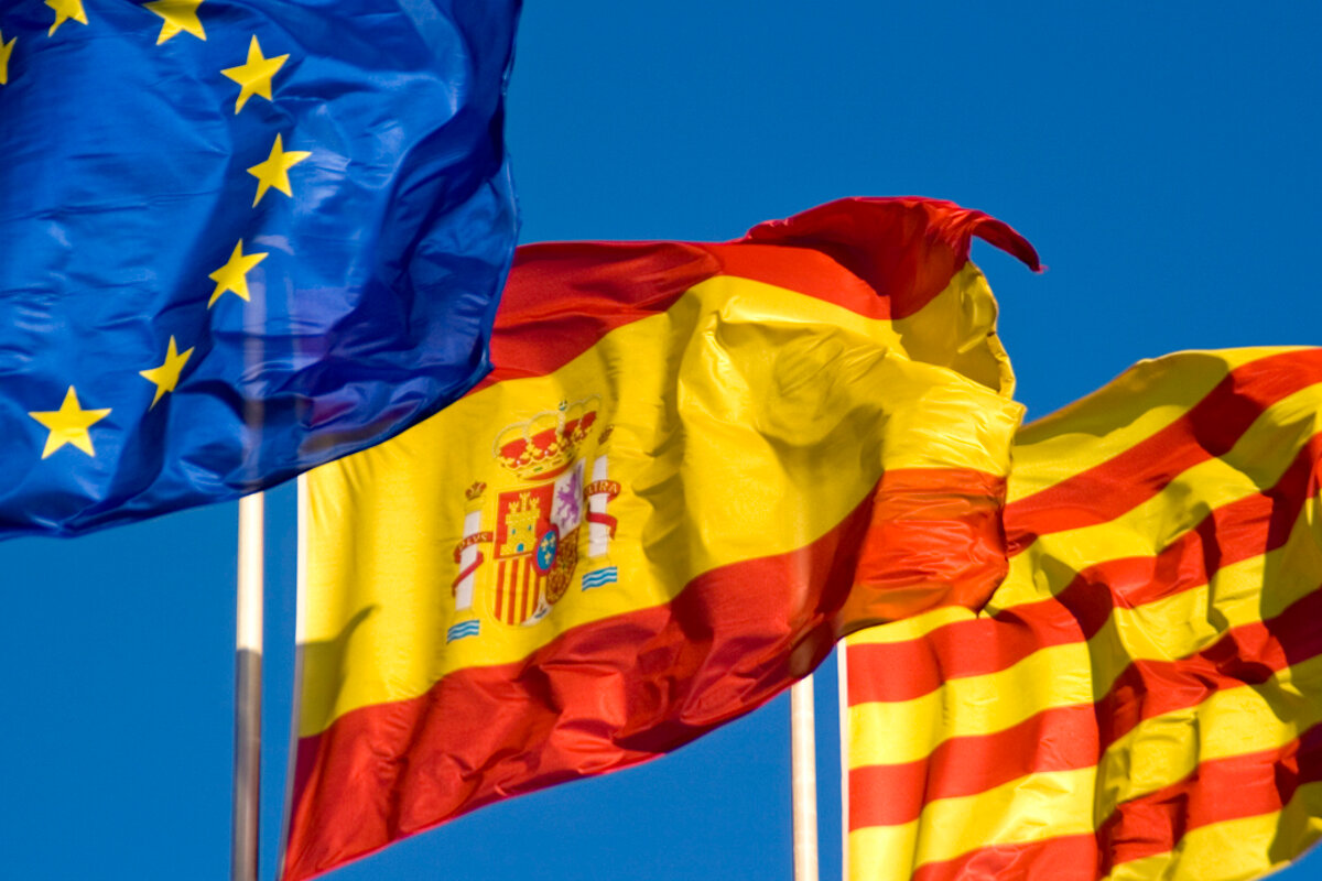 A blue flag with yellow stars is next to a spanish flag