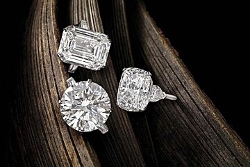 Three diamond rings are sitting on a piece of wood