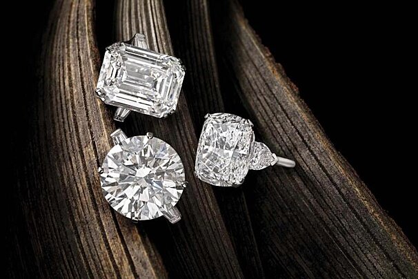 Three diamond rings are sitting on a piece of wood