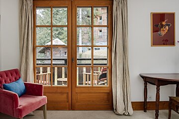 A picture of a cow hangs above a window
