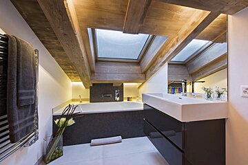 A bathroom with a skylight above the bathtub