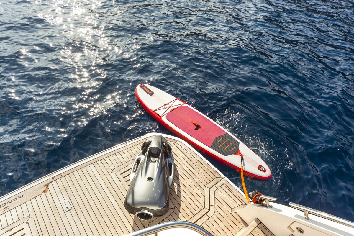A jet ski is attached to a paddle board on the back of a boat