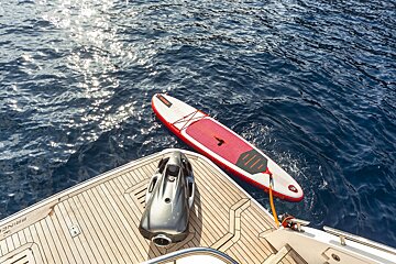 A jet ski is attached to a paddle board on the back of a boat