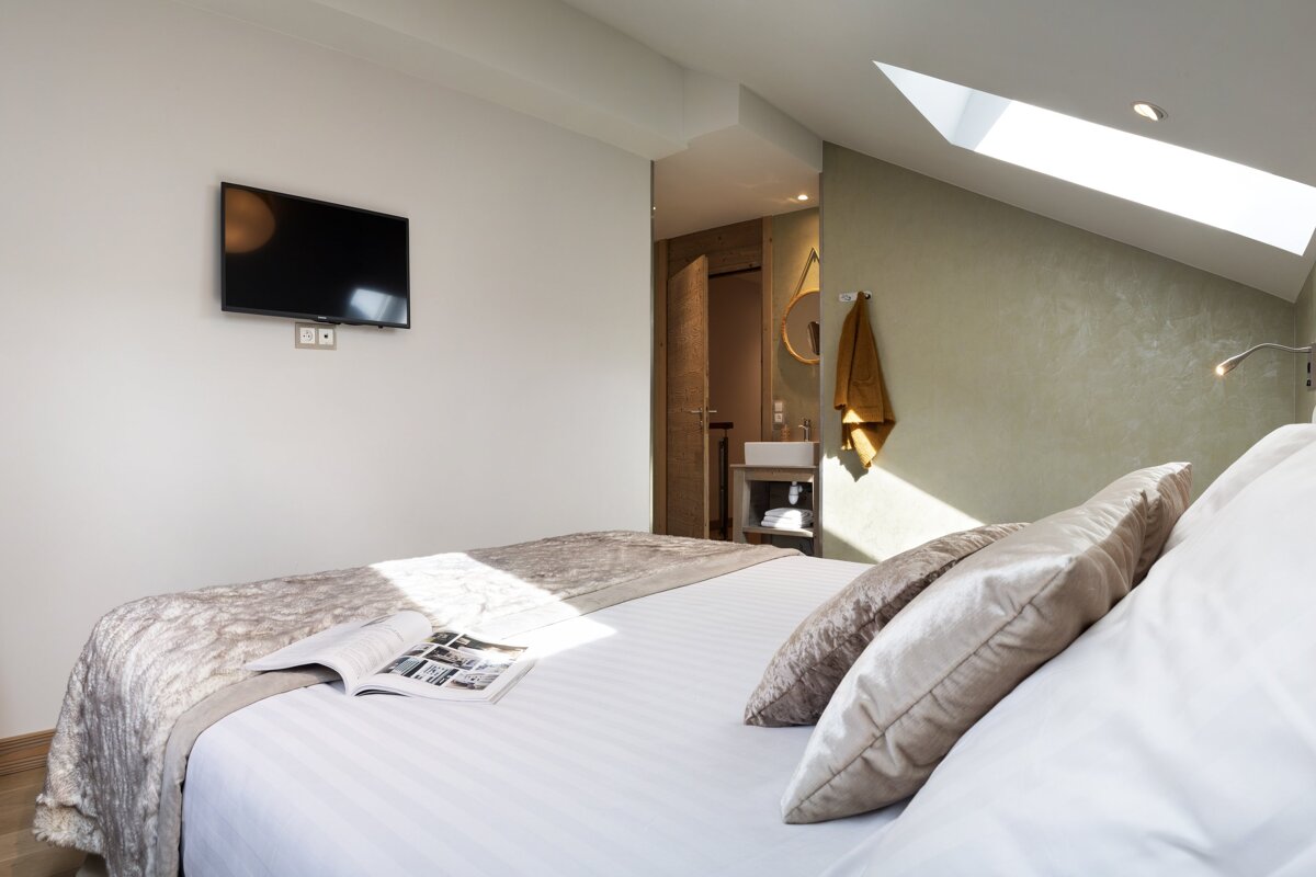 A bedroom with a large bed and a flat screen tv