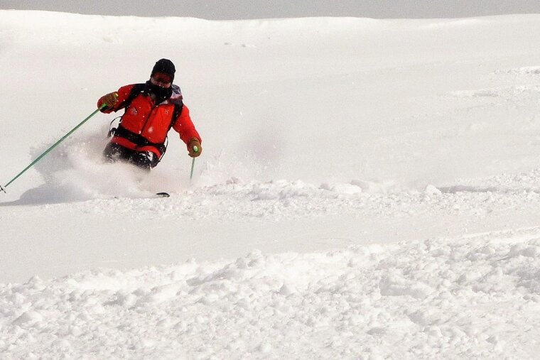 a man in a red ski jacket in deep snow