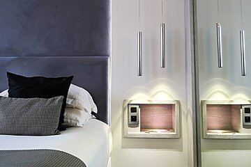 A bed with black pillows and a mirror behind it