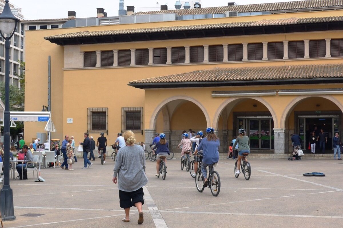 Cyclists passing the Mercat Olivar