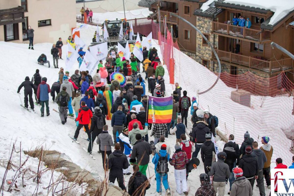 A crowd of people gathered in the snow with a fw logo in the corner