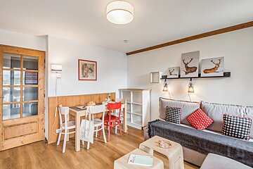 A living room with a couch a table and chairs