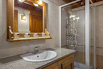 A bathroom with a sink a mirror and a shower