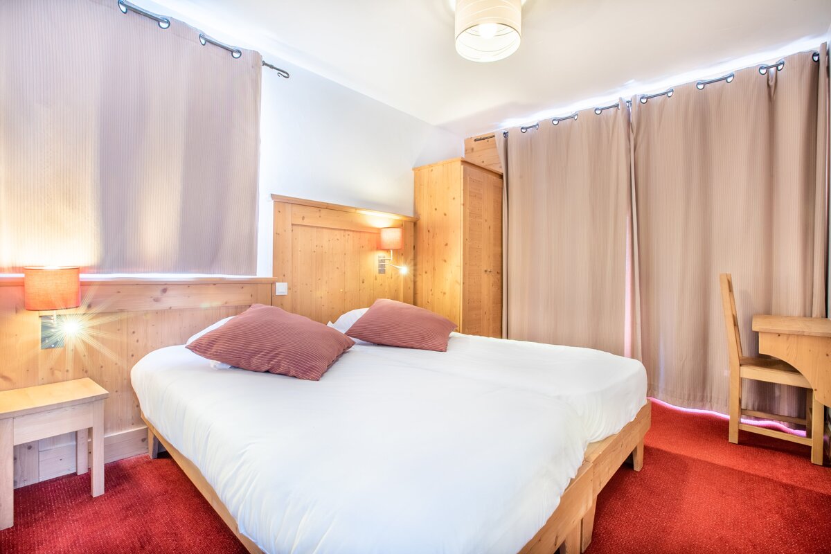 A hotel room with a bed and a desk