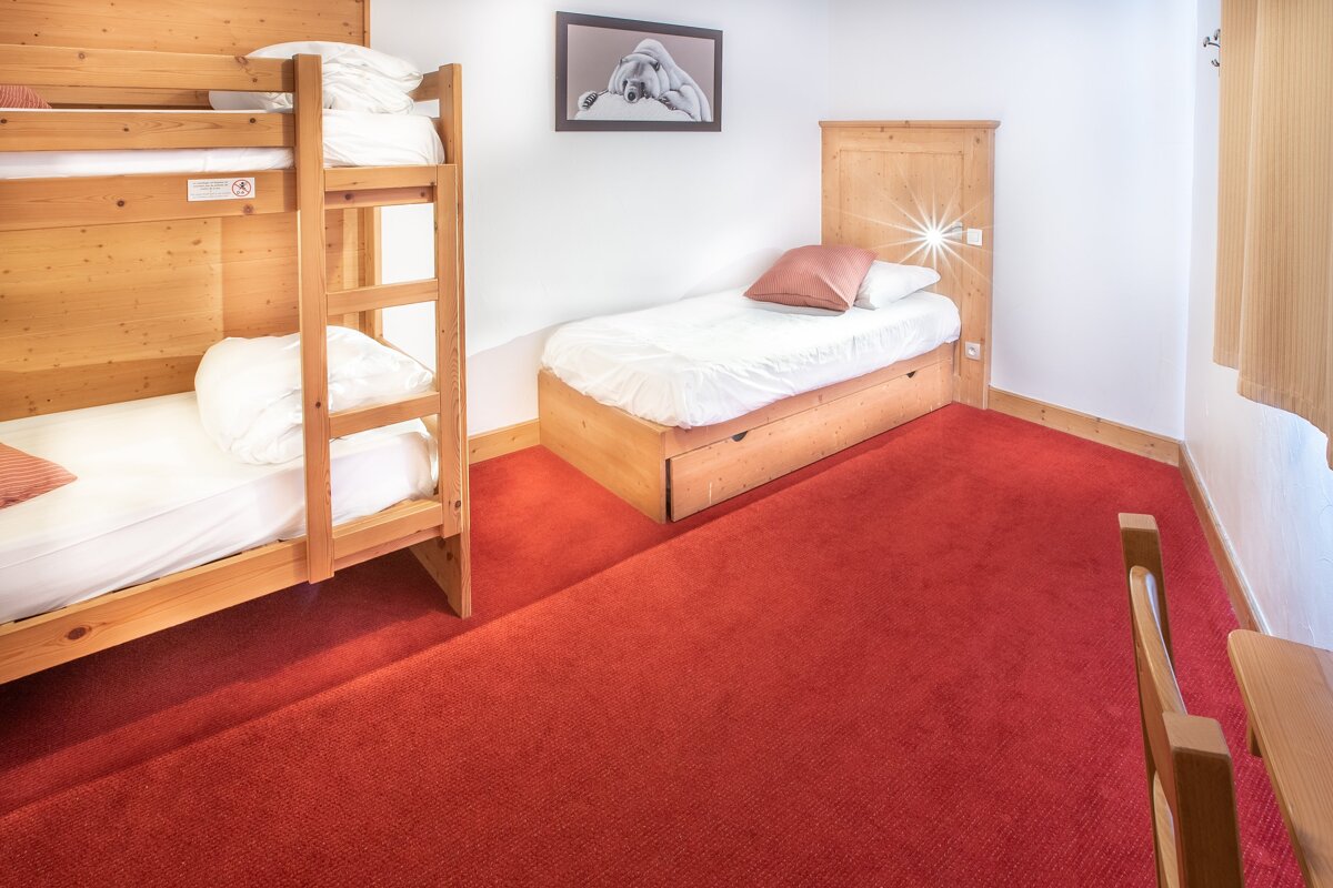 A bedroom with bunk beds and a picture on the wall