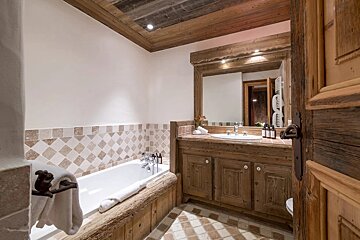 A bathroom with a bathtub a sink and a mirror