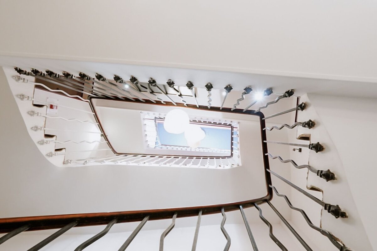 Looking up a spiral staircase with a blue sky in the background