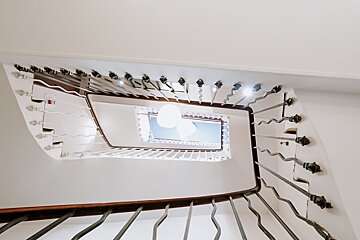 Looking up a spiral staircase with a blue sky in the background