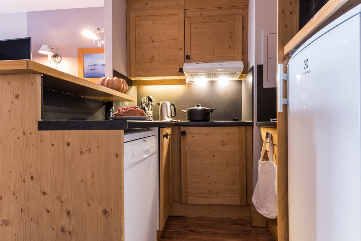A kitchen with wooden cabinets and a white electrolux refrigerator