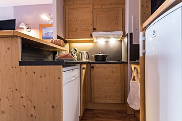A kitchen with wooden cabinets and a white electrolux refrigerator