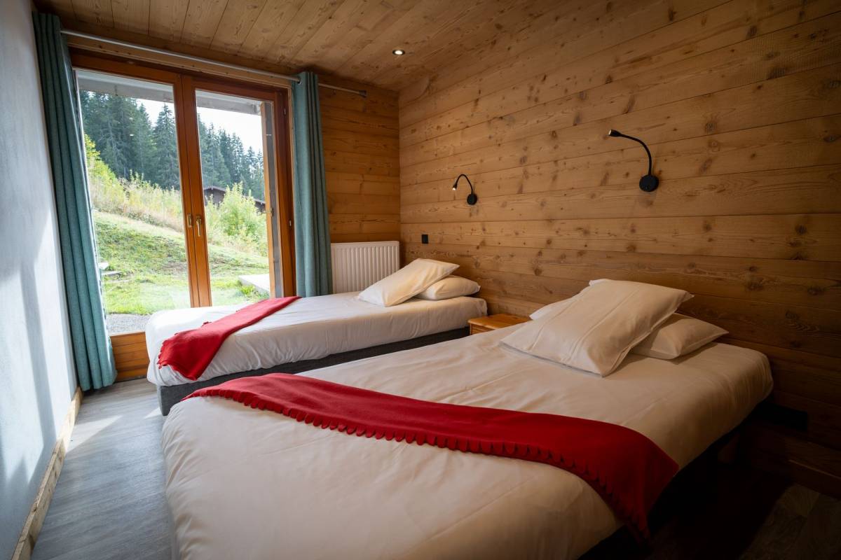 A bedroom with two beds and a large window