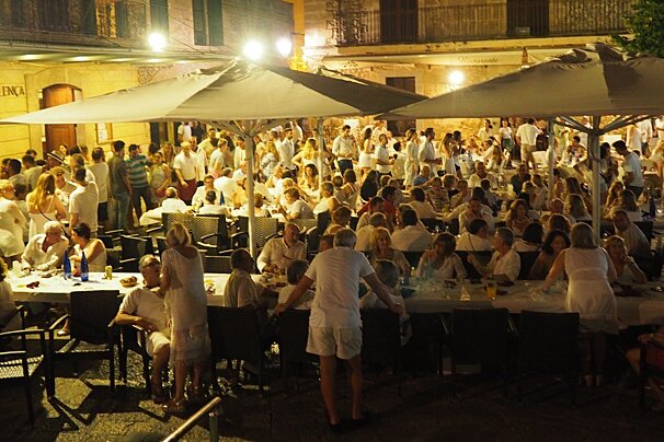 lots of people dressed in white at a festival in mallorca