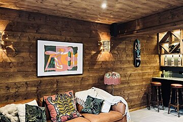 A living room with a couch and a painting on the wall