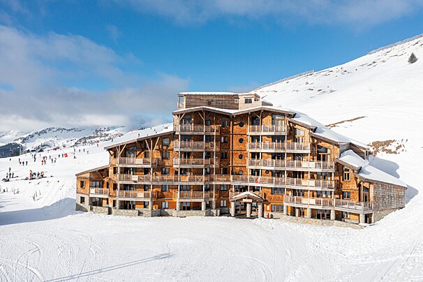 A large wooden building is surrounded by snow