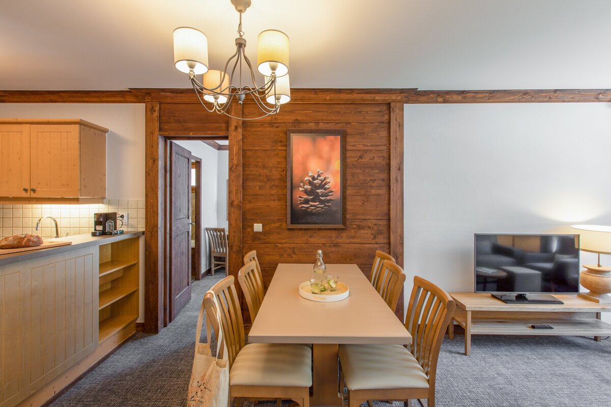 A kitchen with a table and chairs and a picture of a pine cone on the wall