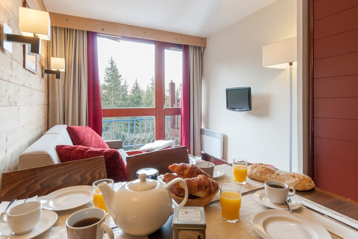 A living room with a couch and a table set for breakfast
