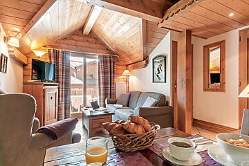 A living room with a basket of croissants on the table