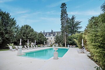 A large swimming pool surrounded by chairs and umbrellas