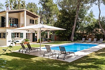 A house with a large swimming pool in front of it