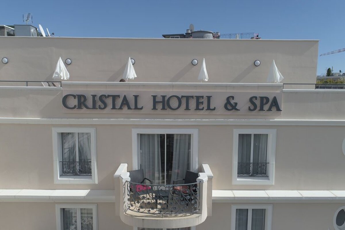 A white building with a sign that says cristal hotel & spa