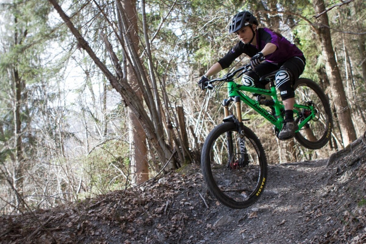 a female mountain biker jumping a small bump