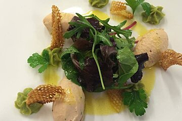 A white plate topped with a salad and a sauce