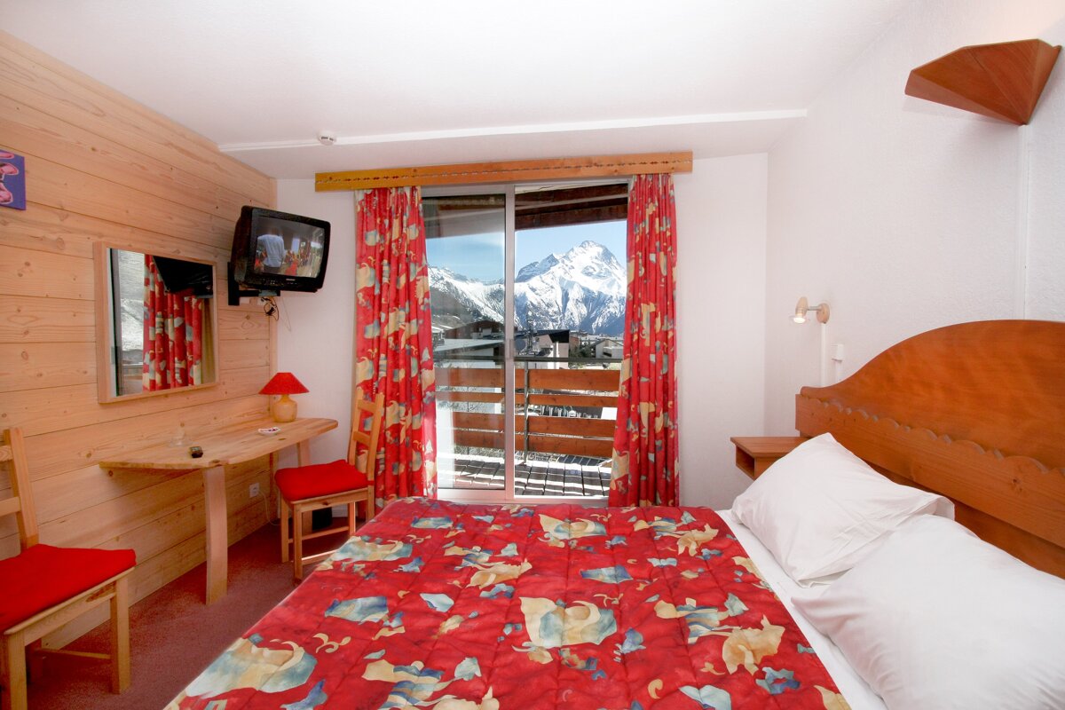 A bedroom with a large bed and a flat screen tv