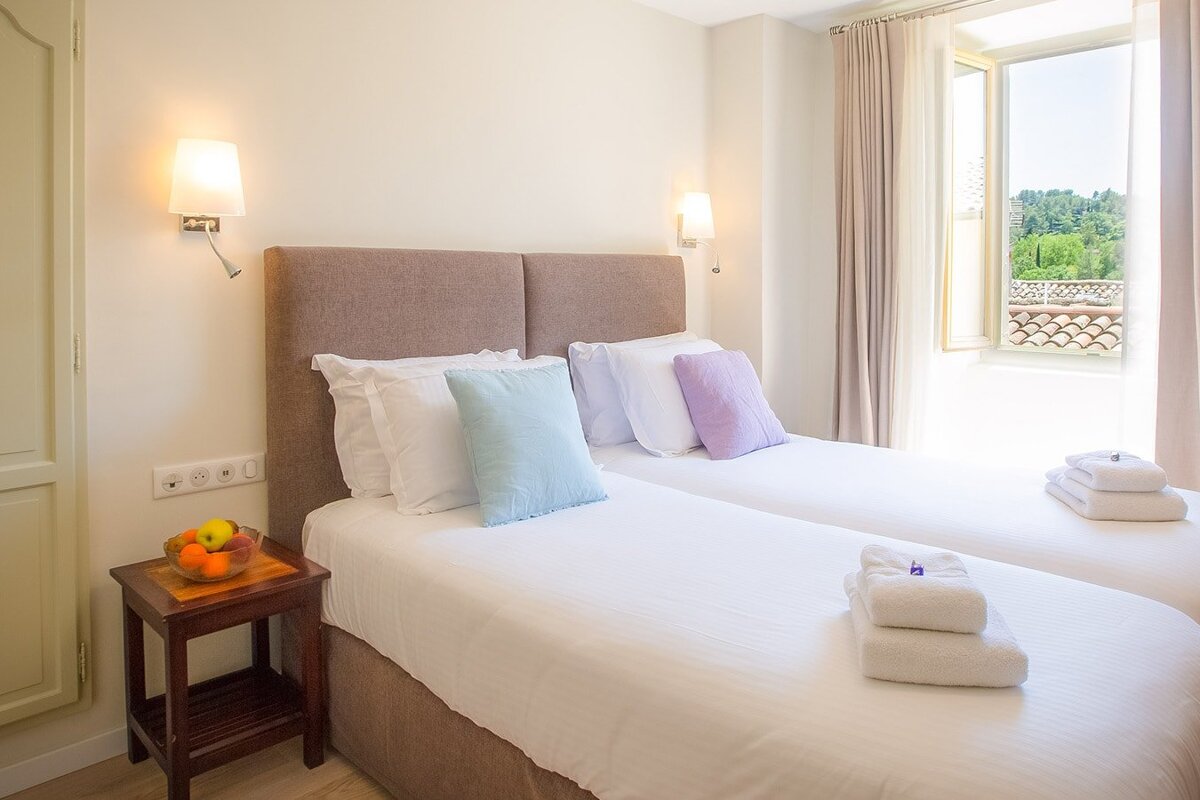 A hotel room with two beds and a window