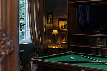 A pool table with cues and a ball on it