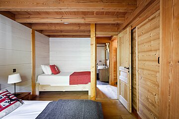 A bedroom with wooden walls and a single bed