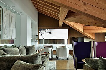 A living room with purple chairs and a large picture on the wall