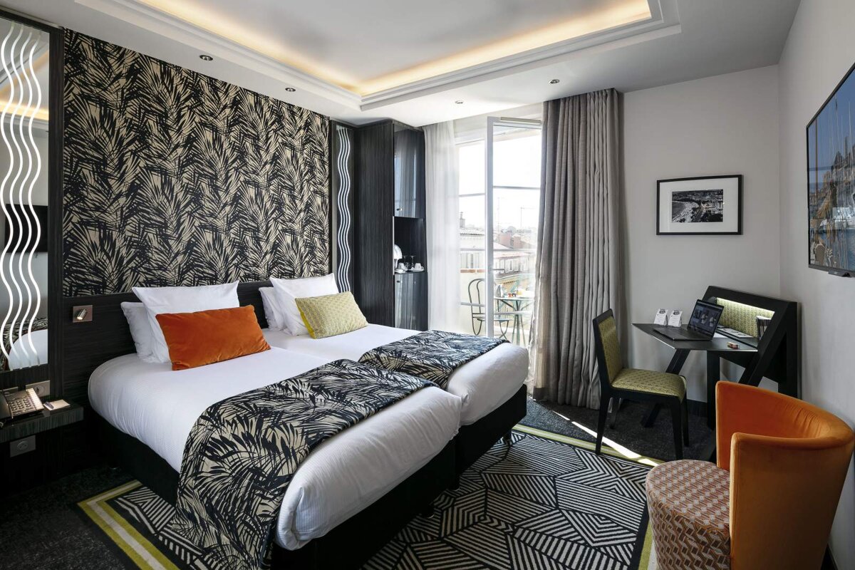 A hotel room with two beds and a desk