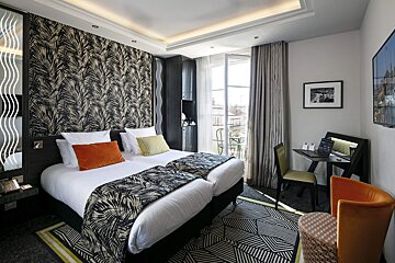 A hotel room with two beds and a desk