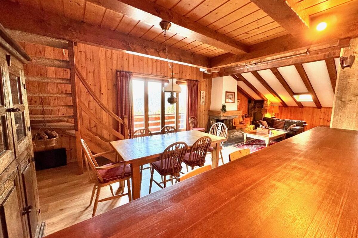 A wooden house with a dining table and chairs