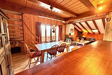 A wooden house with a dining table and chairs