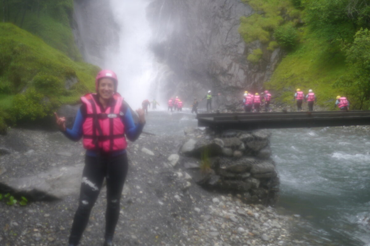 people in life jackets near a waterfall