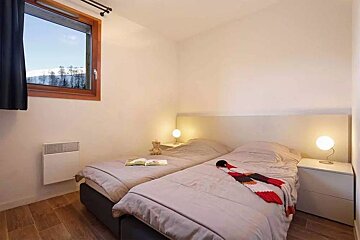 A bedroom with two twin beds and a window