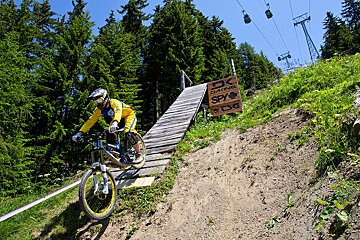 a mountain biker riding off a steep ramp