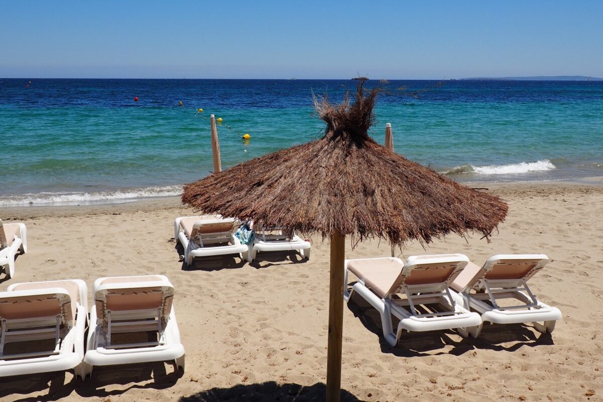 a beach with loungers at playa d'en bossa ibiza