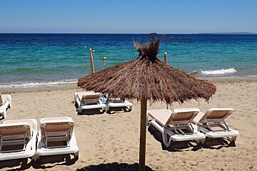 a beach with loungers at playa d'en bossa ibiza
