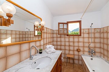 A bathroom with a sink and a tub and a window