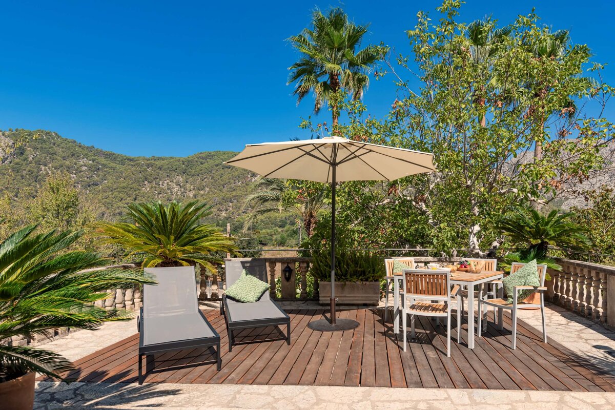 A deck with a table and chairs and an umbrella
